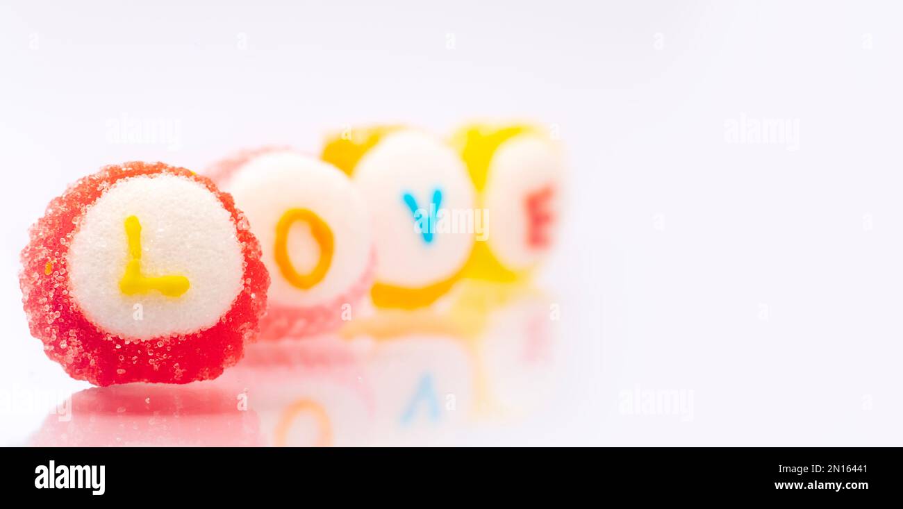 Amore, testo in caramella su sfondo bianco.San Valentino giorno dolce e zucchero. Foto Stock