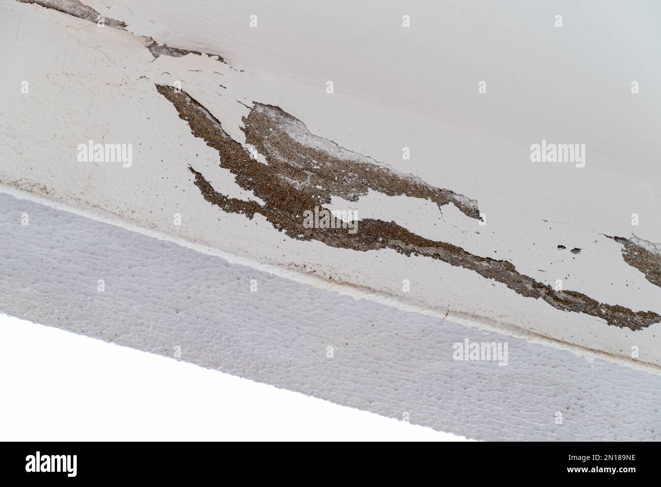 A causa dell'umidità, l'intonaco e le pitture sul soffitto del balcone sono stati sbucciati Foto Stock