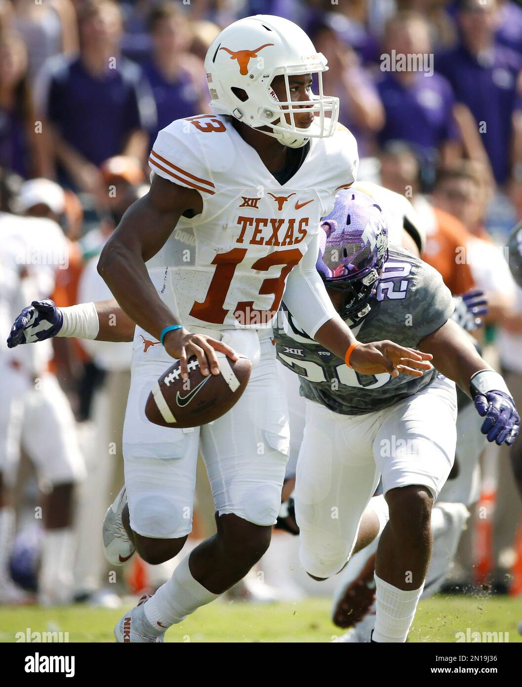 Texas quarterback Jerrod Heard (13) is pursued by TCU linebacker Montrel Wilson (20) in the first half of an NCAA football game Saturday, Oct. 3, 2015, in Fort Worth, Texas. (AP Photo/Ron Jenkins) Foto Stock
