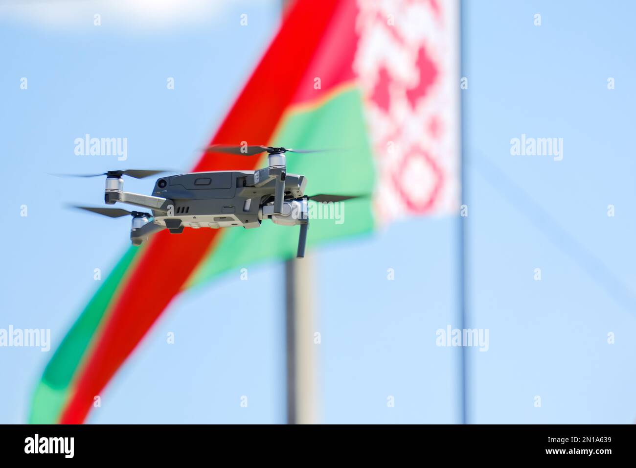 drone copter flag bielorussia blu giorno verde rosso superiore sorveglianza ricerca telecamera controllo lama elica elettronica moderno sfondo cielo nuvole patriotis Foto Stock
