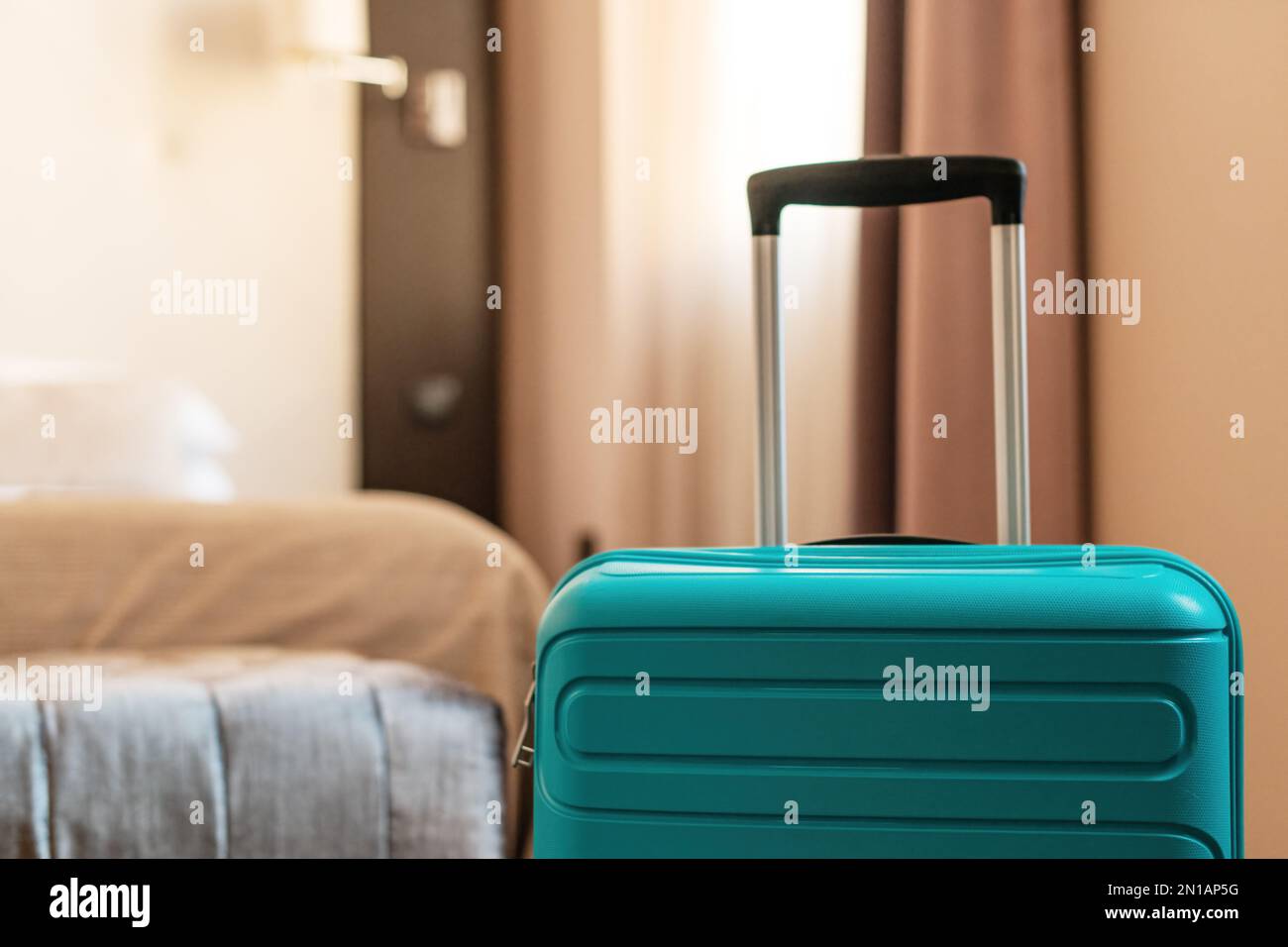 Valigia da viaggio blu nella camera da letto dell'appartamento dell'hotel Foto Stock