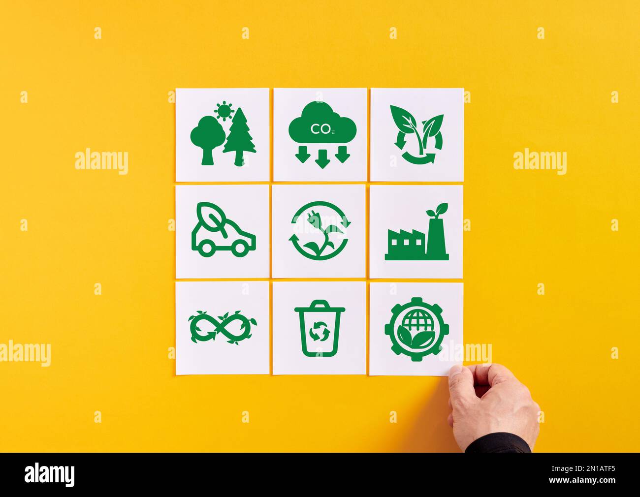 Protezione dell'ambiente, riscaldamento globale e conservazione dell'ecosistema. Dispone a mano le carte di appunti con simboli di protezione ambientale. Foto Stock
