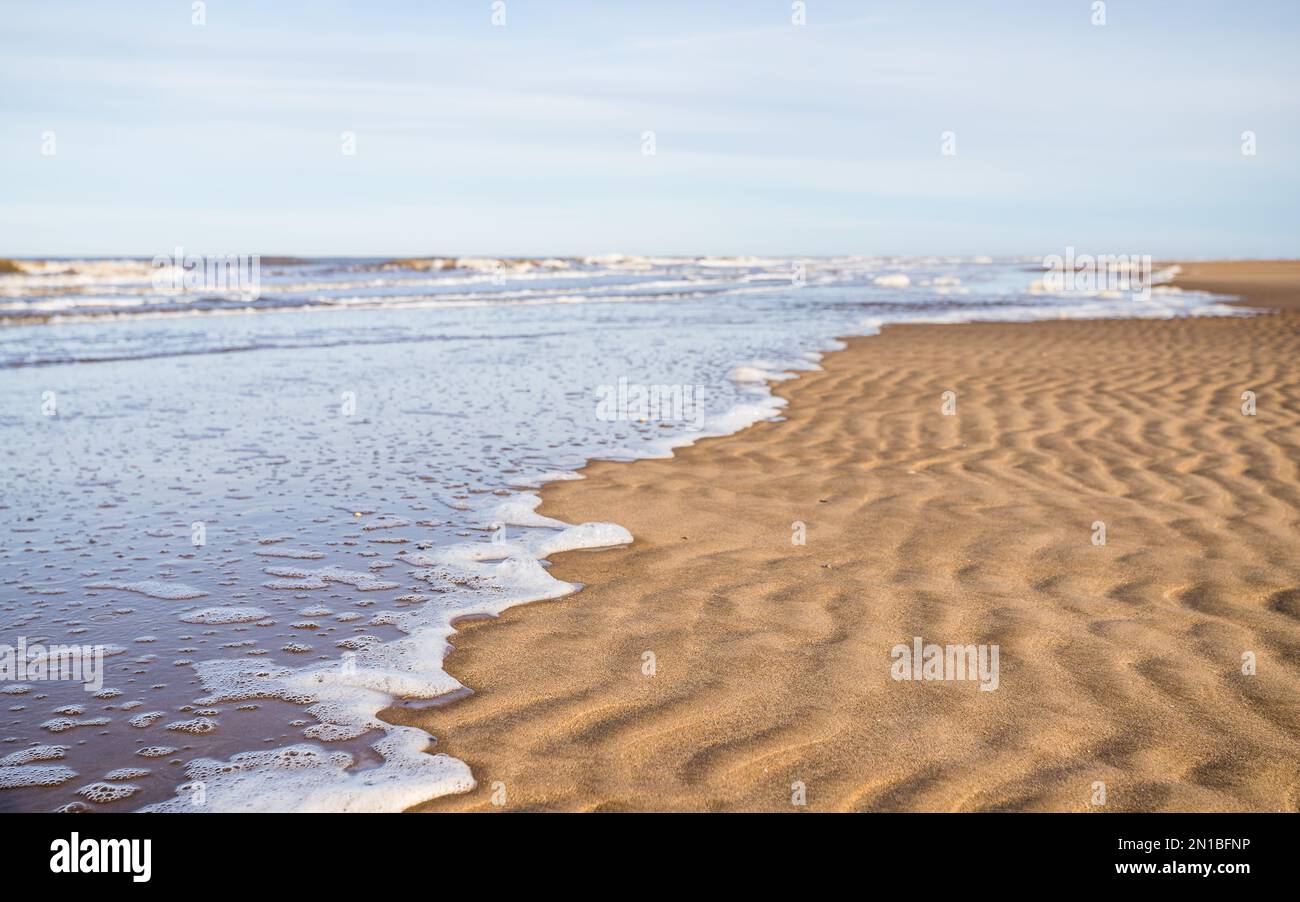 L'acqua copre lentamente la spiaggia di Ainsdale sulla costa di Sefton. Foto Stock