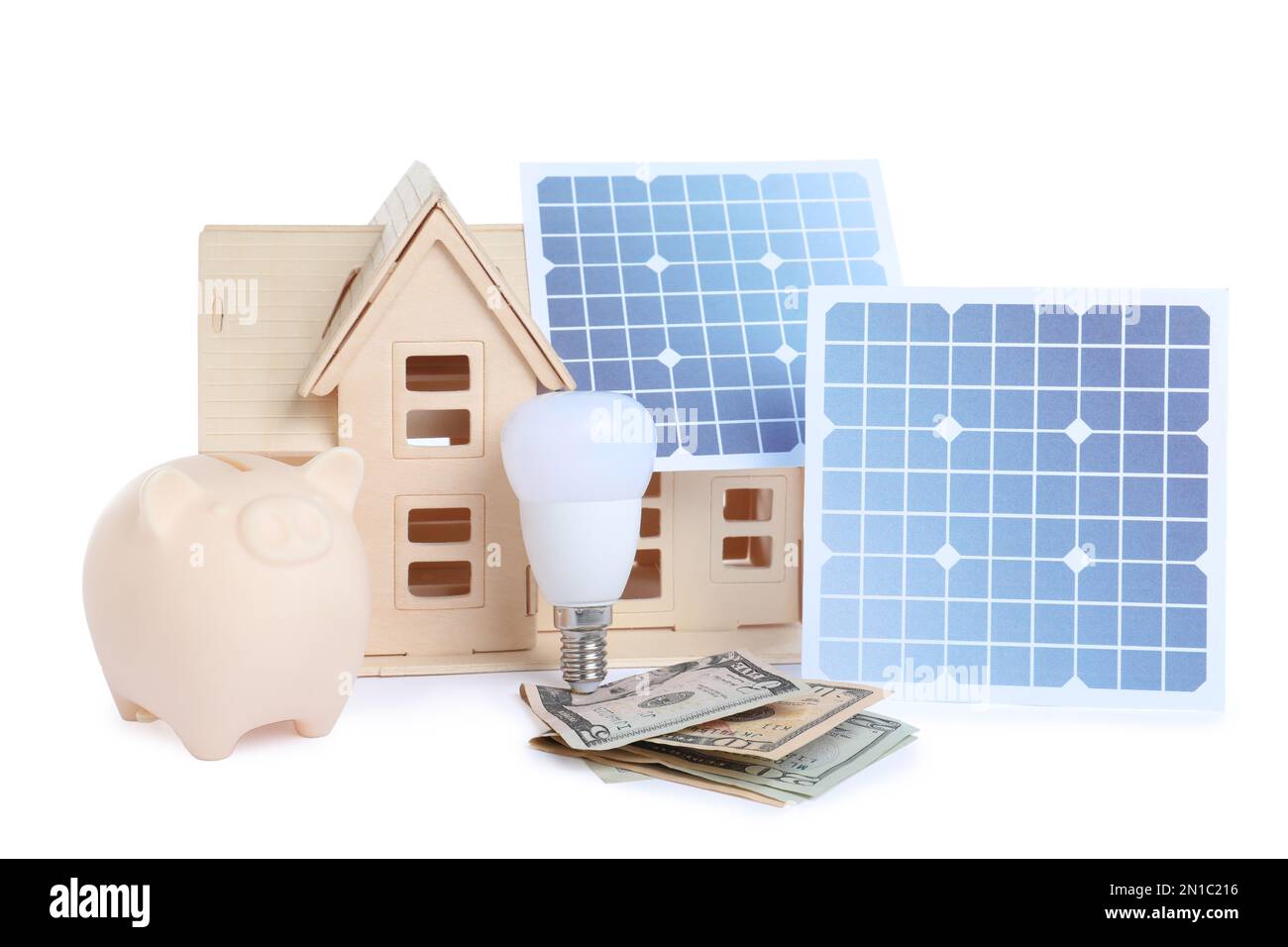 Composizione con pannelli solari e modello di casa in legno su sfondo bianco Foto Stock