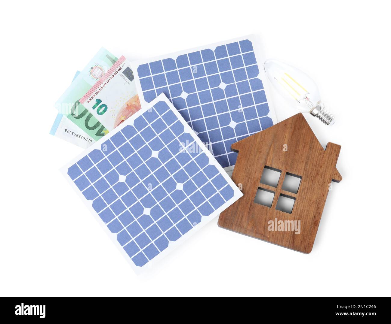Composizione con pannelli solari e modello di casa in legno su sfondo bianco, vista dall'alto Foto Stock