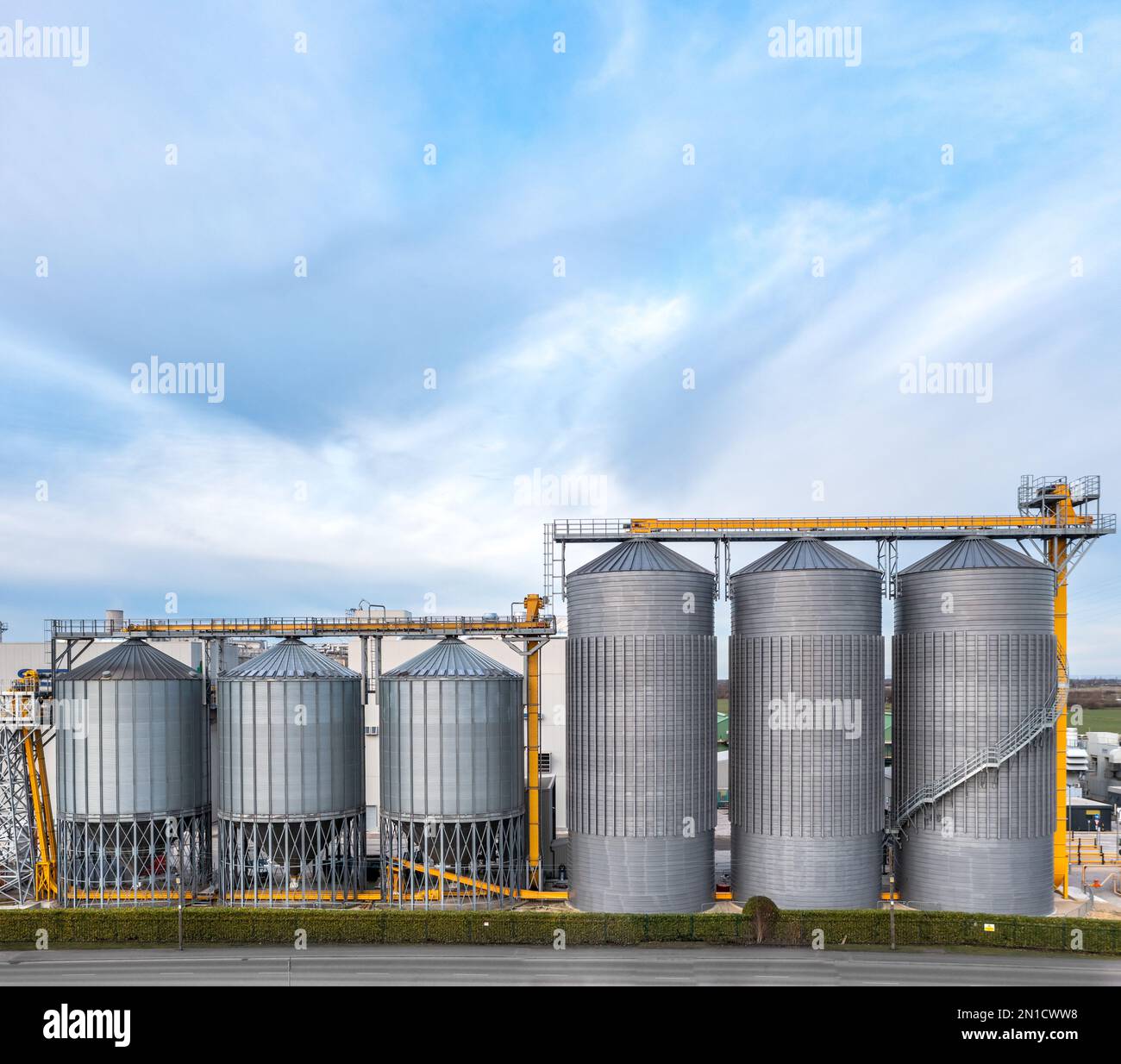 Una fila di serbatoi di stoccaggio industriali o silos su larga scala in un impianto chimico con spazio di copia sopra Foto Stock