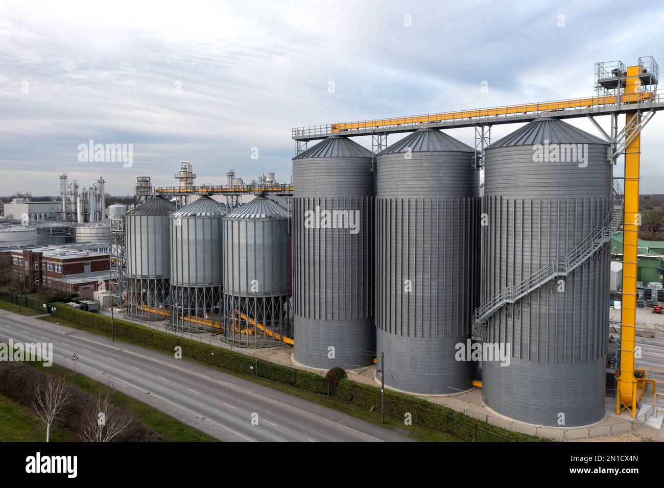Una fila di serbatoi di stoccaggio industriali o silos su larga scala in un impianto chimico con spazio di copia sopra Foto Stock