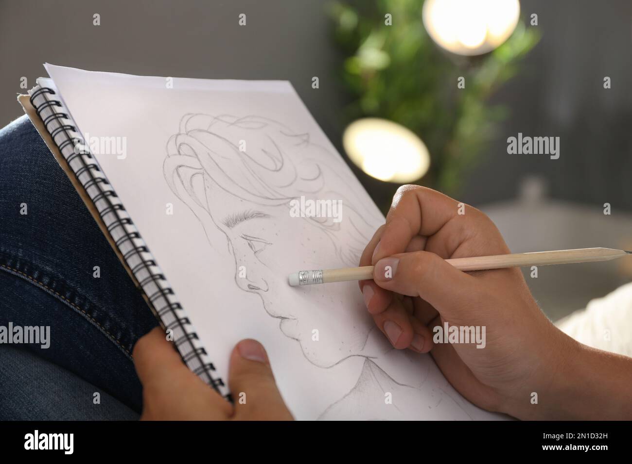 Uomo disegno ritratto con matita in blocco note interni, primo piano Foto Stock