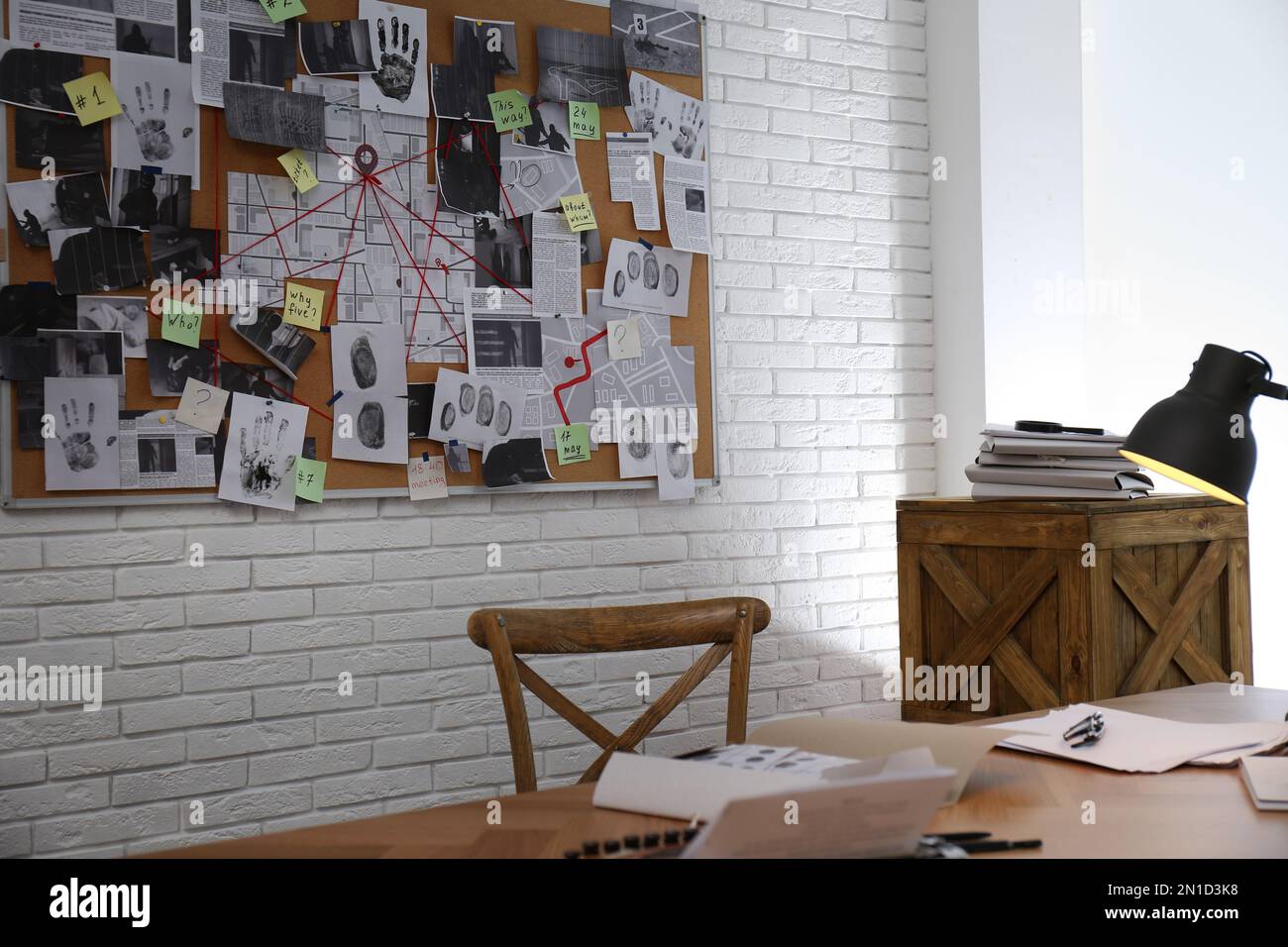 Interno ufficio detective con posto di lavoro e quadro di indagine Foto Stock