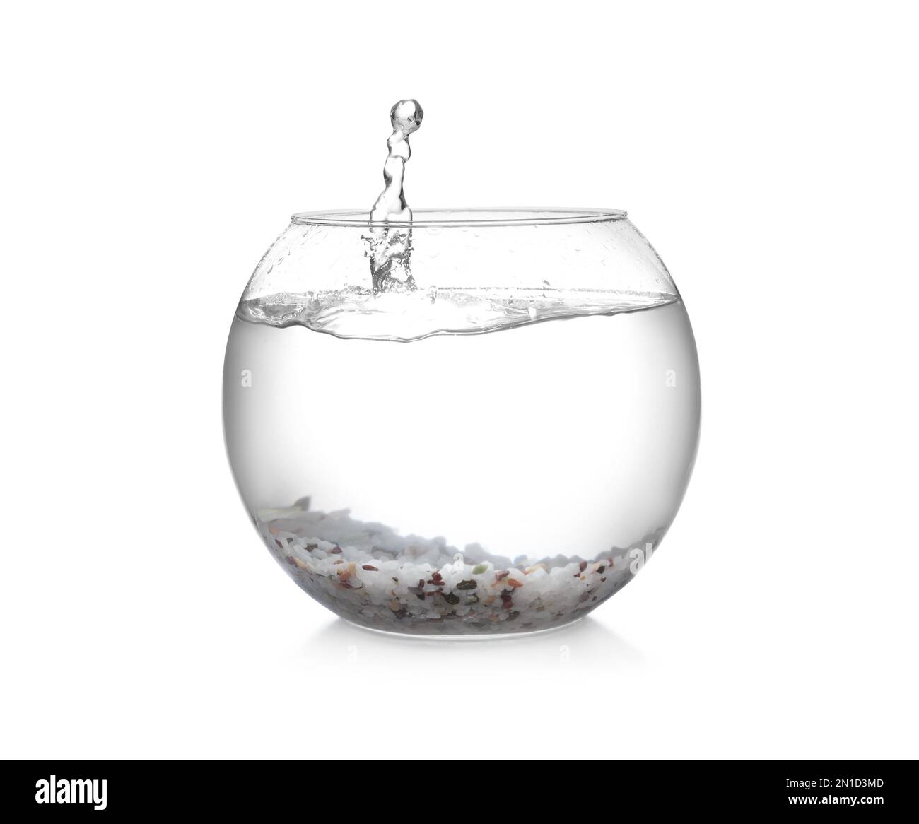 Spruzzi d'acqua in una ciotola di pesce rotonda con ciottoli decorativi su sfondo bianco Foto Stock