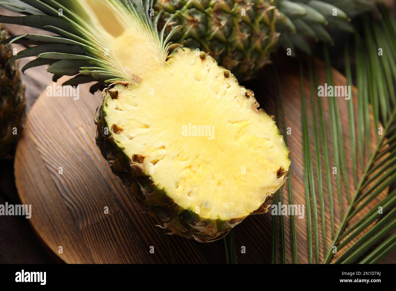 Metà ananas su asse di legno, primo piano Foto Stock