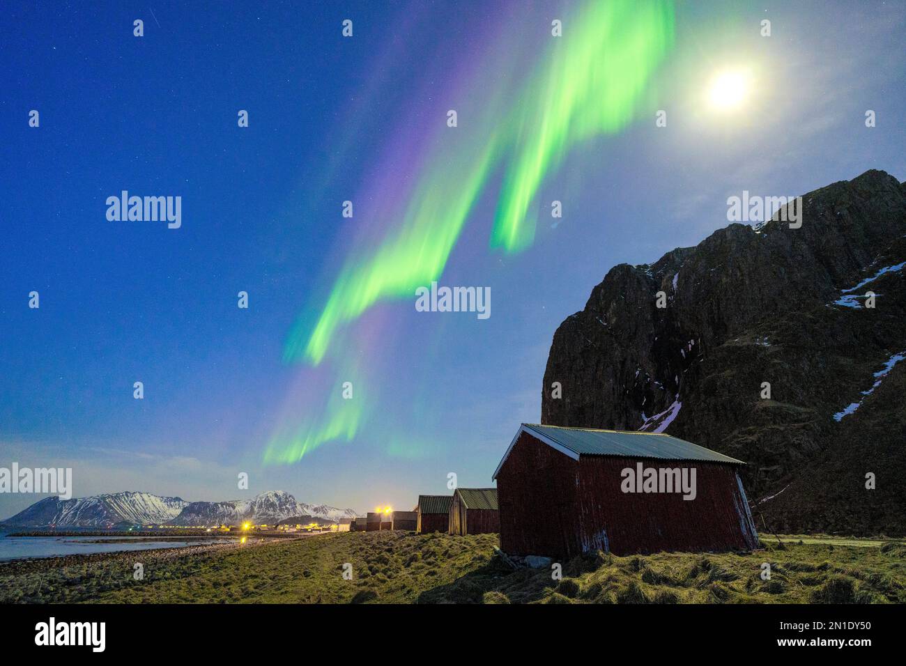 Al chiaro di luna sopra il villaggio di pescatori di Eggum sotto l'aurora boreale (aurora boreale), Vestvagoy, contea di Nordland, Isole Lofoten, Norvegia Foto Stock