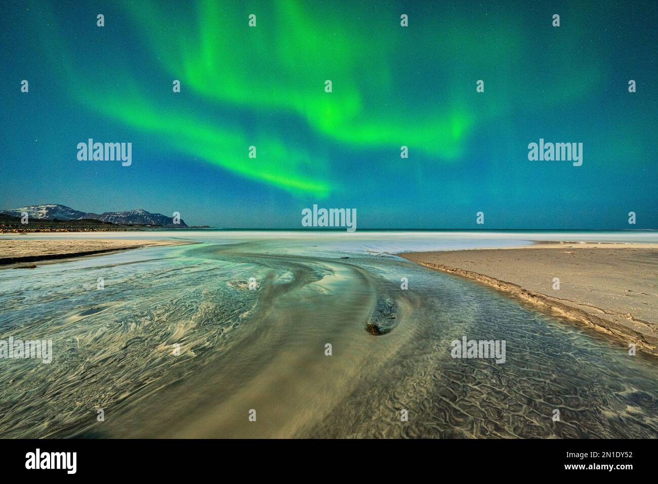 Sabbia increspata bagnata dalle onde durante l'aurora boreale, la spiaggia di Skagsanden, Ramberg, la contea di Nordland, le isole Lofoten, Norvegia Foto Stock
