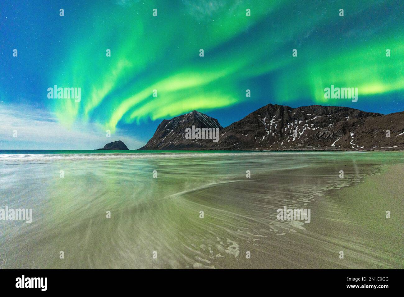 Onde che si schiantano sulla spiaggia di Haukland, sotto l'aurora boreale (Aurora borealis), Leknes, contea di Nordland, Isole Lofoten, Norvegia, Scandinavia Foto Stock
