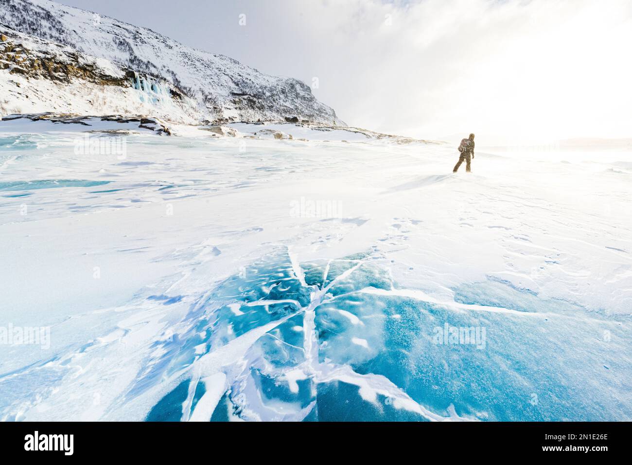 Escursionista esplorando il paesaggio innevato camminando sul lago ghiacciato in inverno, Stora Sjofallet, Norrbotten County, Lapponia, Svezia, Scandinavia, Europa Foto Stock