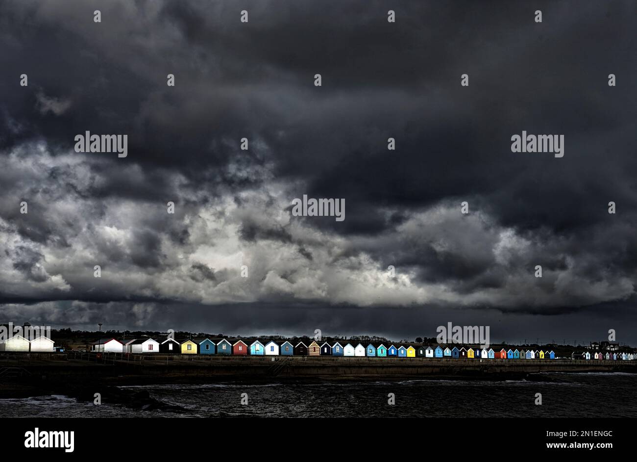 capanne sulla spiaggia di southwold con il cielo tempestoso minaccioso Foto Stock