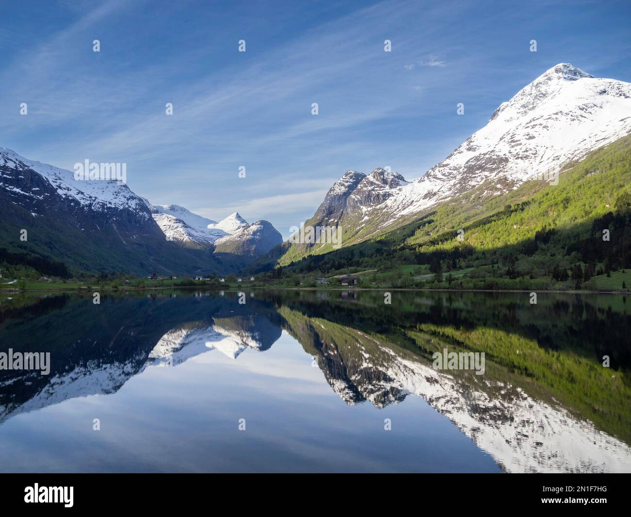 Una vista sulle montagne innevate e le riflessioni sul lago Oldevatnet, all'interno della valle del fiume Oldedalen, Vestland, Norvegia, Scandinavia, Europa Foto Stock