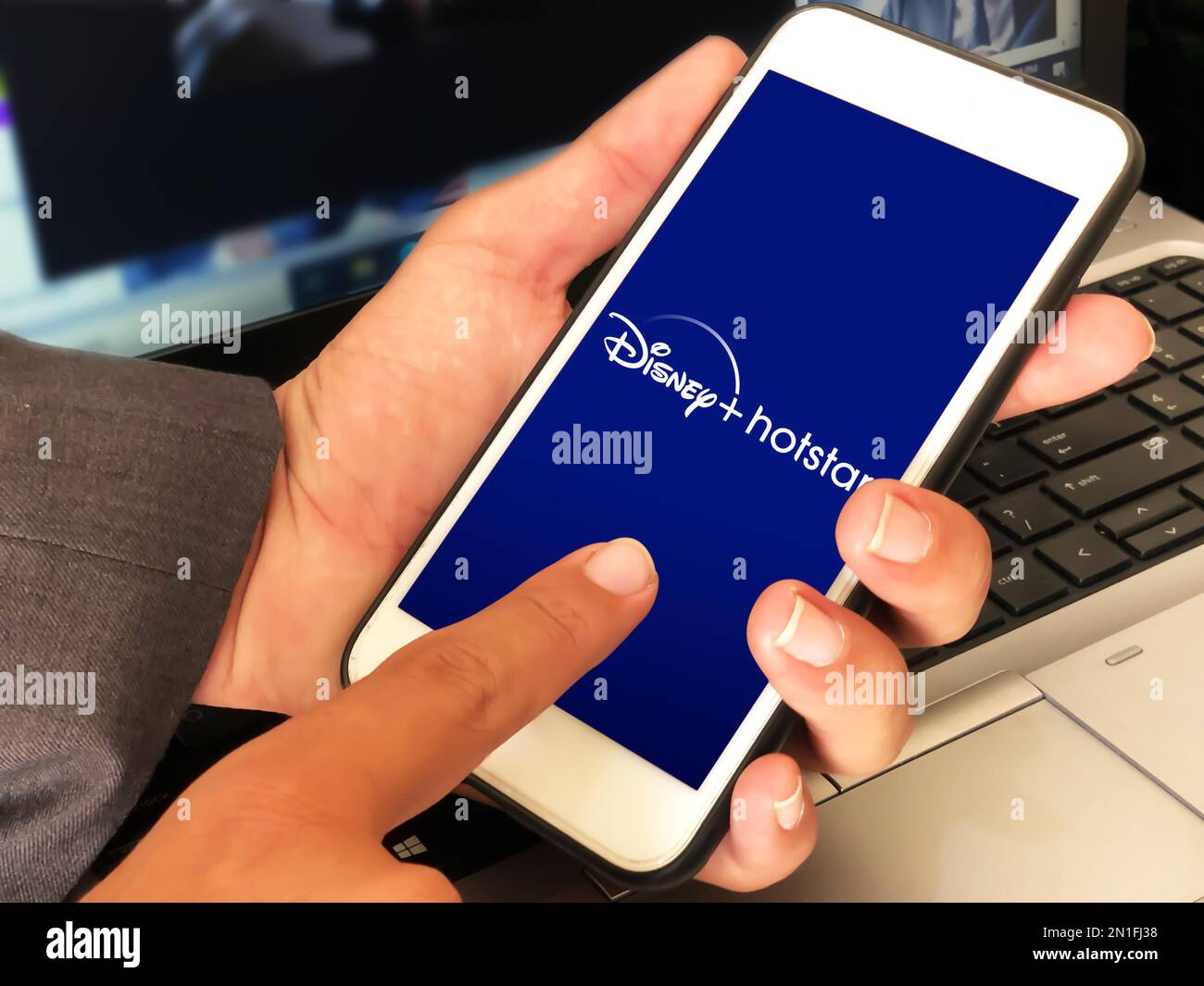 Disney hotstar ott piattaforma di streaming background editoriale con applicazione aperta su cellulare. Uomo che usa disney hotstar su cellulare Foto Stock