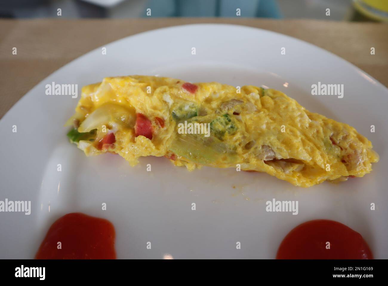 Soffice omelette per la colazione con sugo di carne su piatto bianco Foto Stock