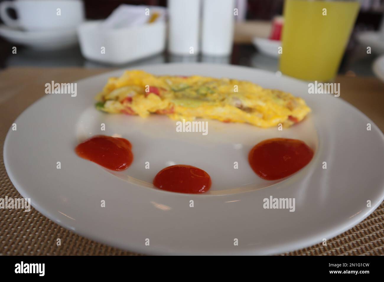 Soffice omelette per la colazione con sugo di carne su piatto bianco Foto Stock