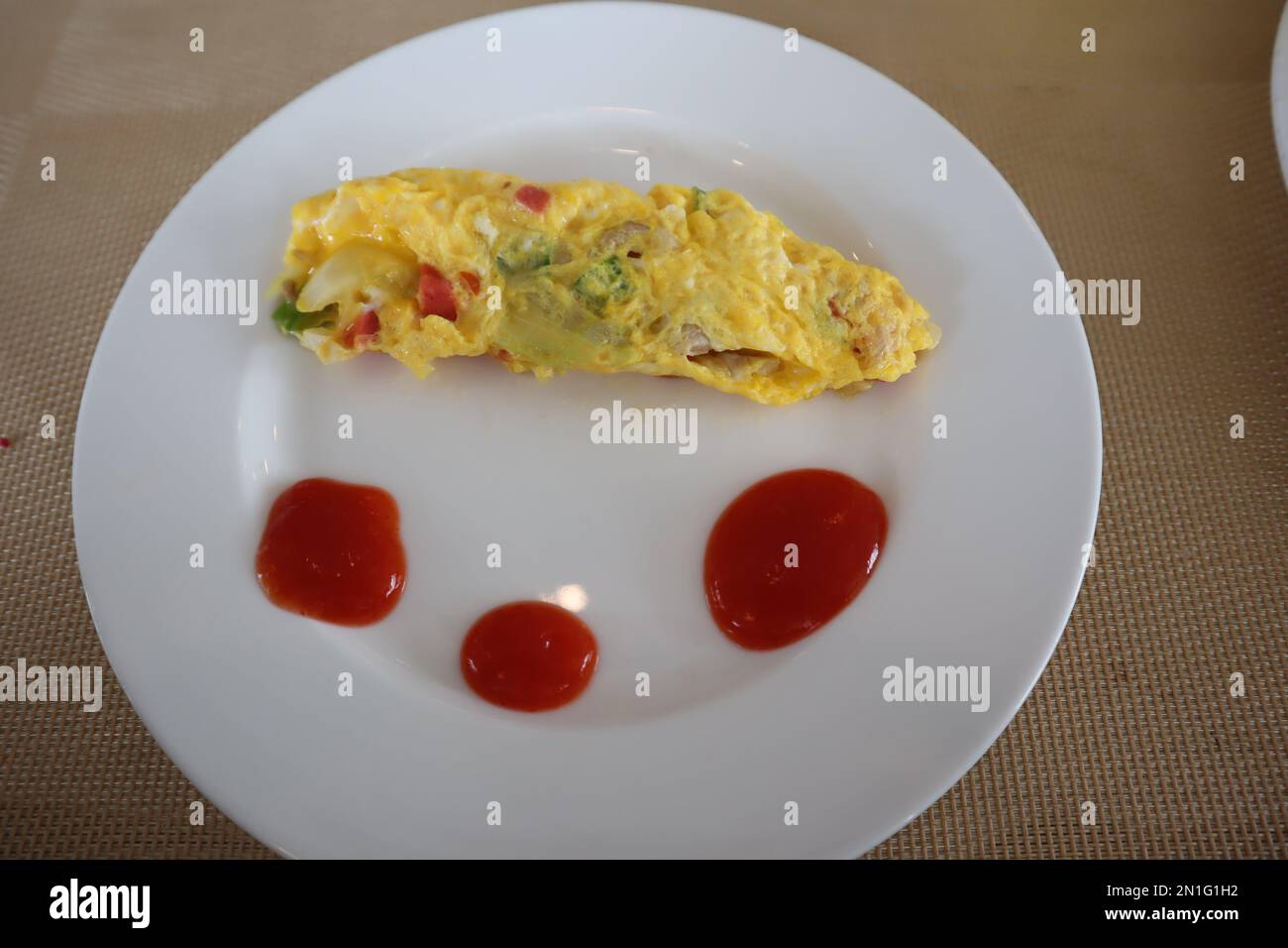Soffice omelette per la colazione con sugo di carne su piatto bianco Foto Stock
