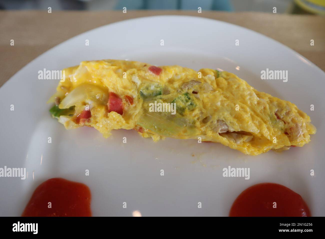 Soffice omelette per la colazione con sugo di carne su piatto bianco Foto Stock