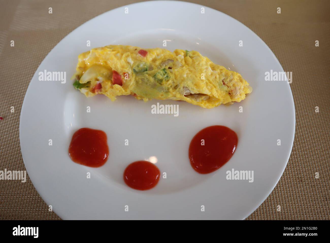Soffice omelette per la colazione con sugo di carne su piatto bianco Foto Stock