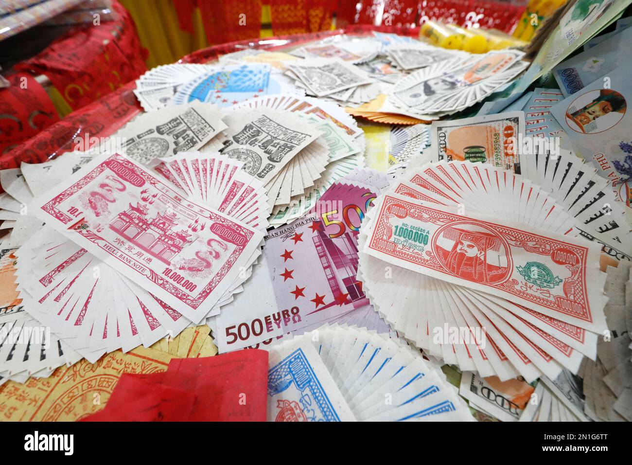 Burning hell banca banconote e altre forme di carta di joss per la cerimonia buddista e taoista, Phuoc lungo tempio buddista, Tan Chau, Vietnam, Indocina, Sout Foto Stock