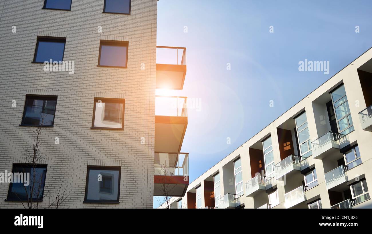 Esterno di nuovi edifici di appartamenti su uno sfondo blu cielo nuvoloso. Nessuna gente. Concetto di business immobiliare. Foto Stock