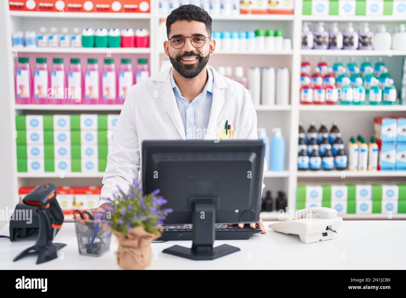 Uomo ispanico con barba che lavora in farmacia con un sorriso felice e  fresco sul viso. persona fortunata Foto stock - Alamy