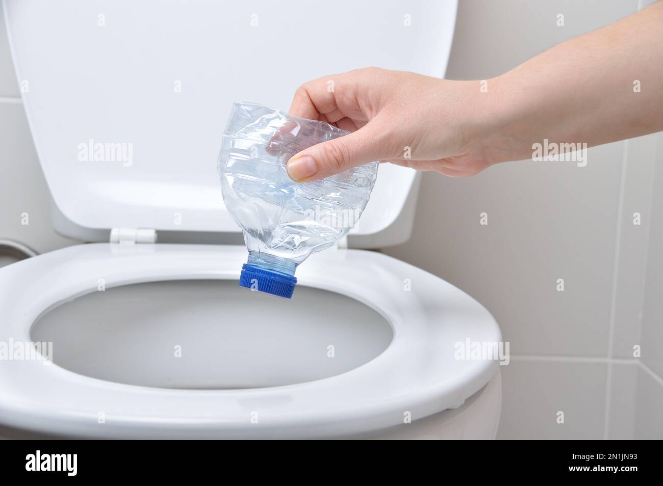 mano di una persona che cade la plastica e non rispetta l'ambiente Foto Stock