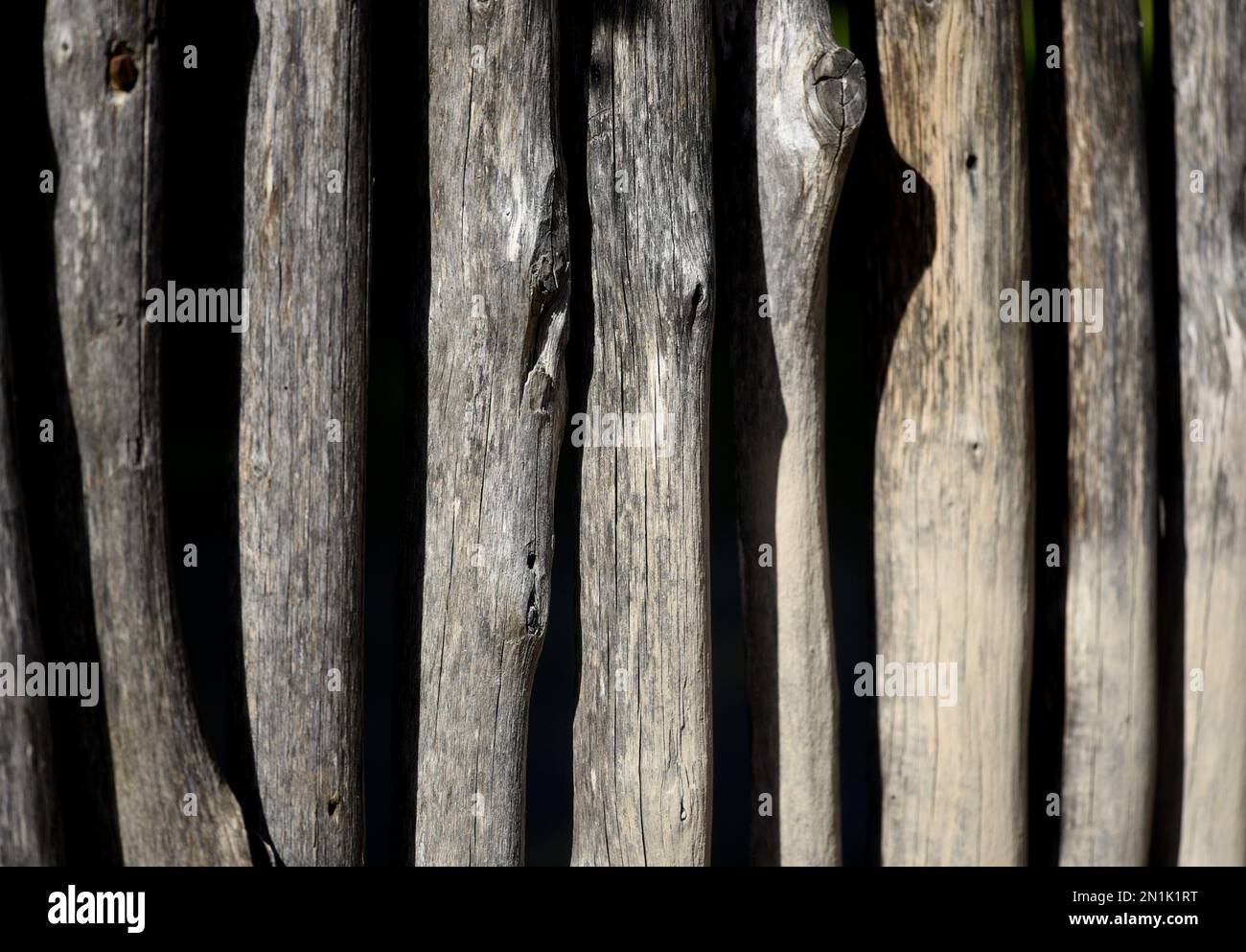 Recinzione fatta a mano con pali di tronco di albero. Foto Stock