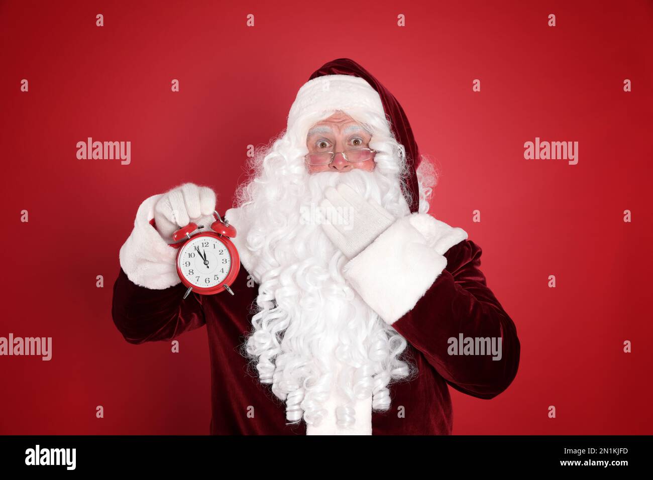 Babbo Natale con sveglia su sfondo rosso. Conto alla rovescia di Natale  Foto stock - Alamy