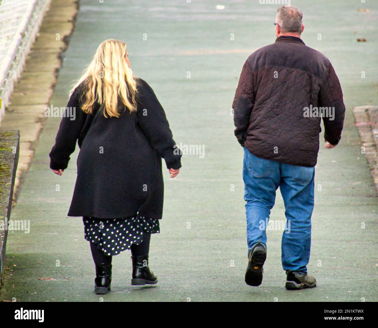 Persone in sovrappeso che camminano sulla passerella Clydeside sul Broomielaw Foto Stock
