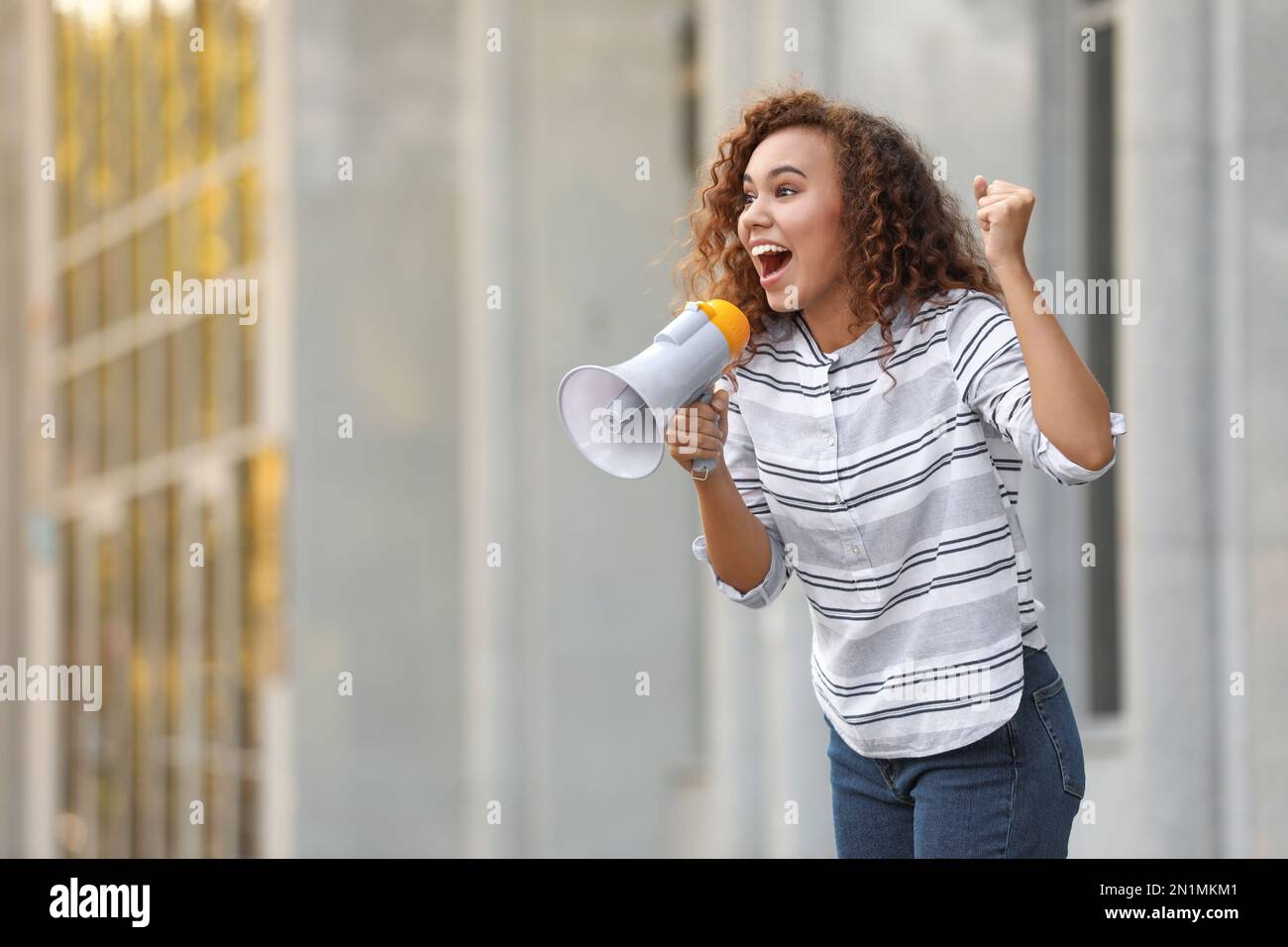 Emotiva giovane afroamericana con megafone all'aperto. Leader di protesta Foto Stock