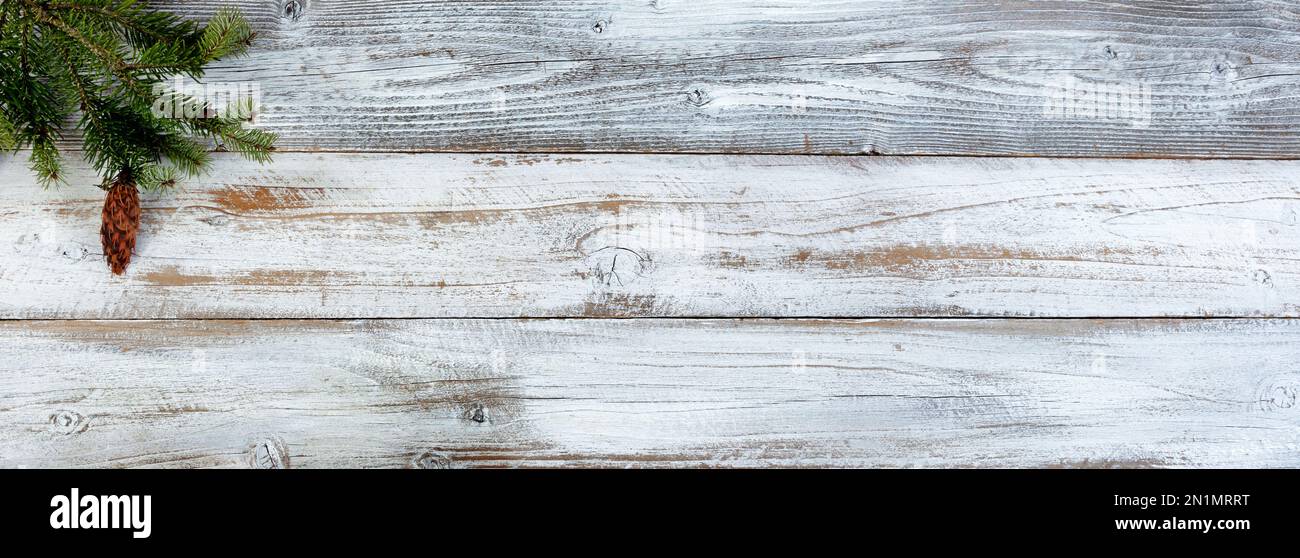 Decorazione natalizia con ramo di abete su sfondo bianco in legno invecchiato Foto Stock