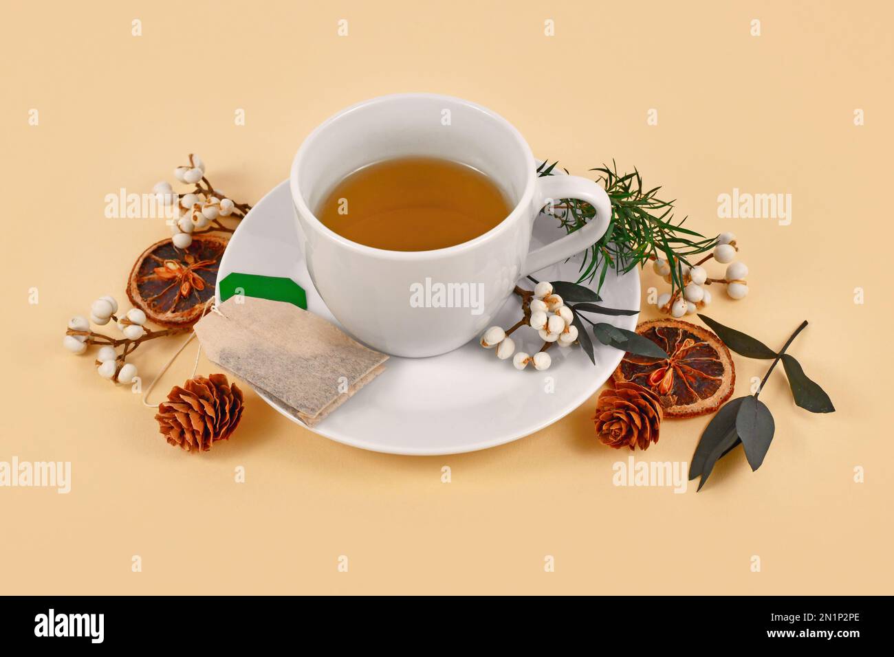 Tazza da tè circondata da decorazioni stagionali della foresta su sfondo beige Foto Stock