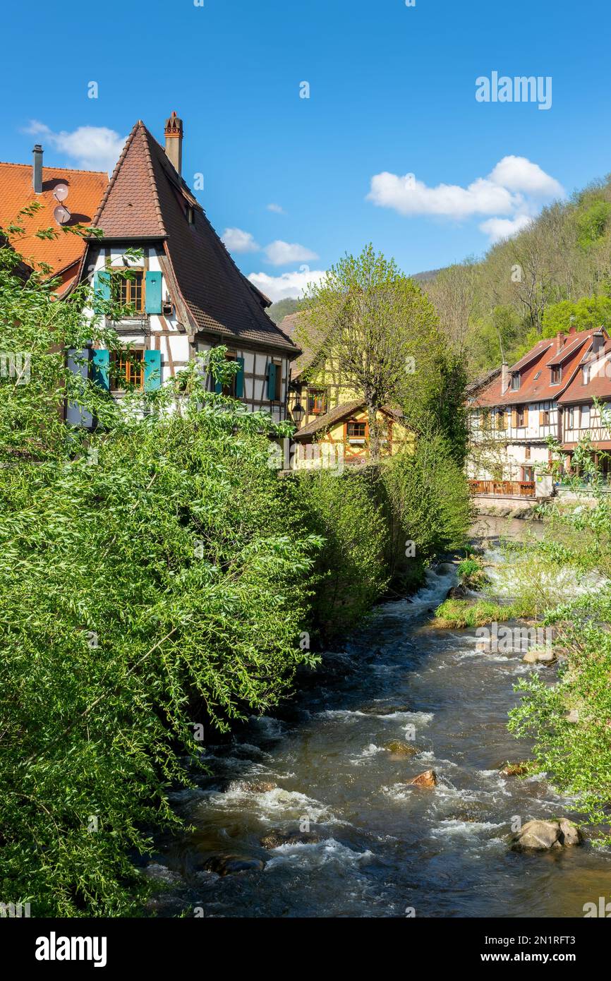 Case alsaziane colorate vicino al fiume nel villaggio turistico di Kaysersberg nella regione Alsazia, Francia Foto Stock