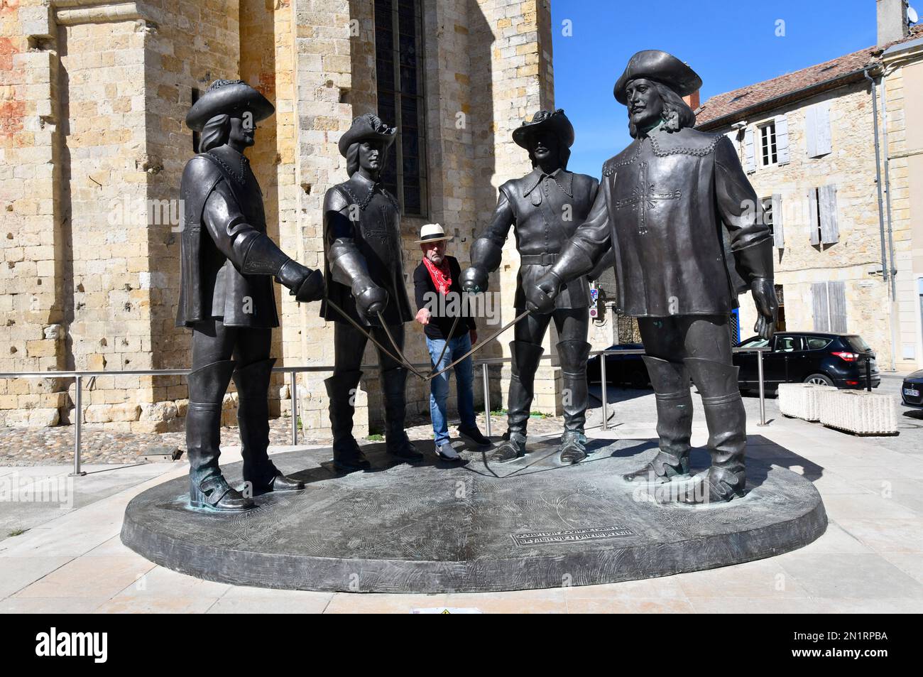 Posa turistica con la statua di d'Artagnan e i tre moschettieri a Condom, Gers, Guascogna, Midi-Pirenei, Francia Condom nel Lot-et-Garonne partenza Foto Stock