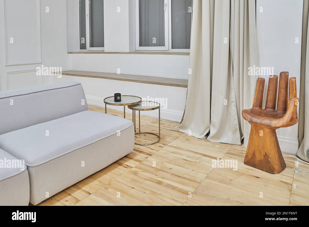 Primo piano di una parte del divano e di una sedia a forma di mano in un  moderno soggiorno interno. Quantità minima di mobili con spazio per la  copia. Foto di alta