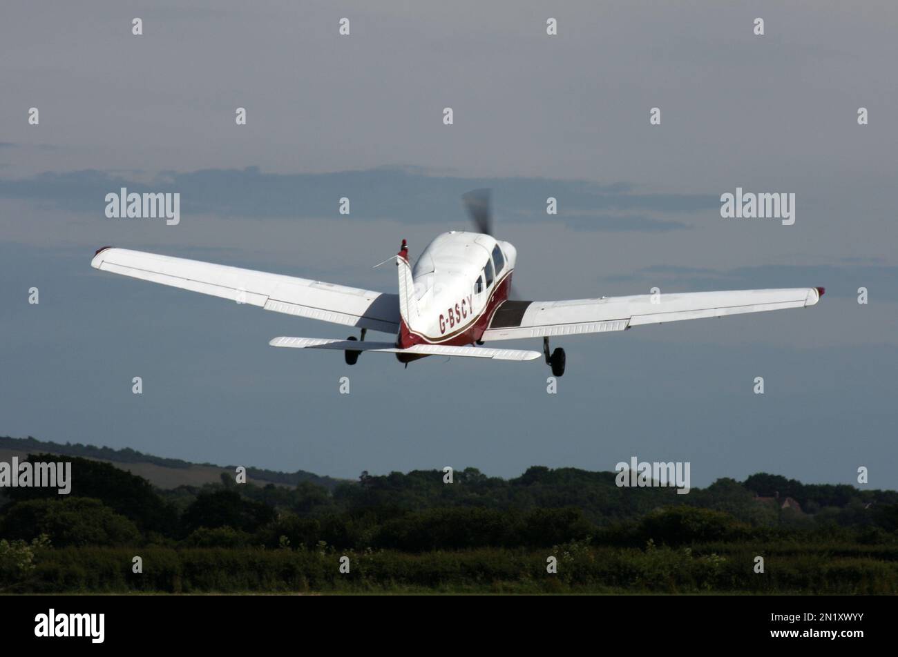 Un Piper PA-28-151 Cherokee parte da un campo aereo privato nel Regno Unito del Sussex orientale in un cielo serale Foto Stock