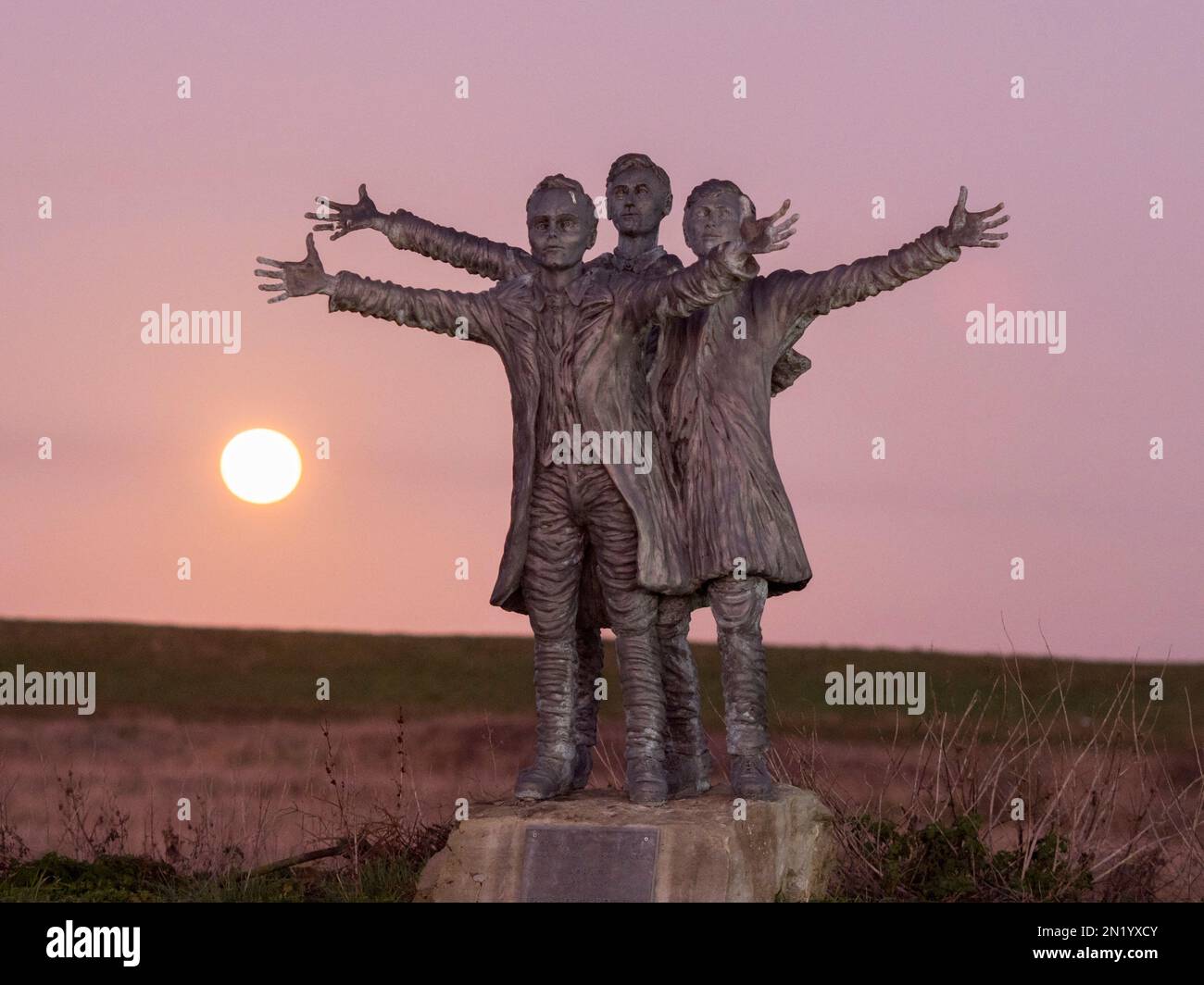 Leysdown, Kent, Regno Unito. 6th Feb, 2023. UK Weather: La Luna di neve visto salire dietro una statua di British Aviation pionieri The Short Brothers - vicino a dove hanno fondato la prima fabbrica di aeroplani al mondo a Leysdown, Kent. Credit: James Bell/Alamy Live News Foto Stock