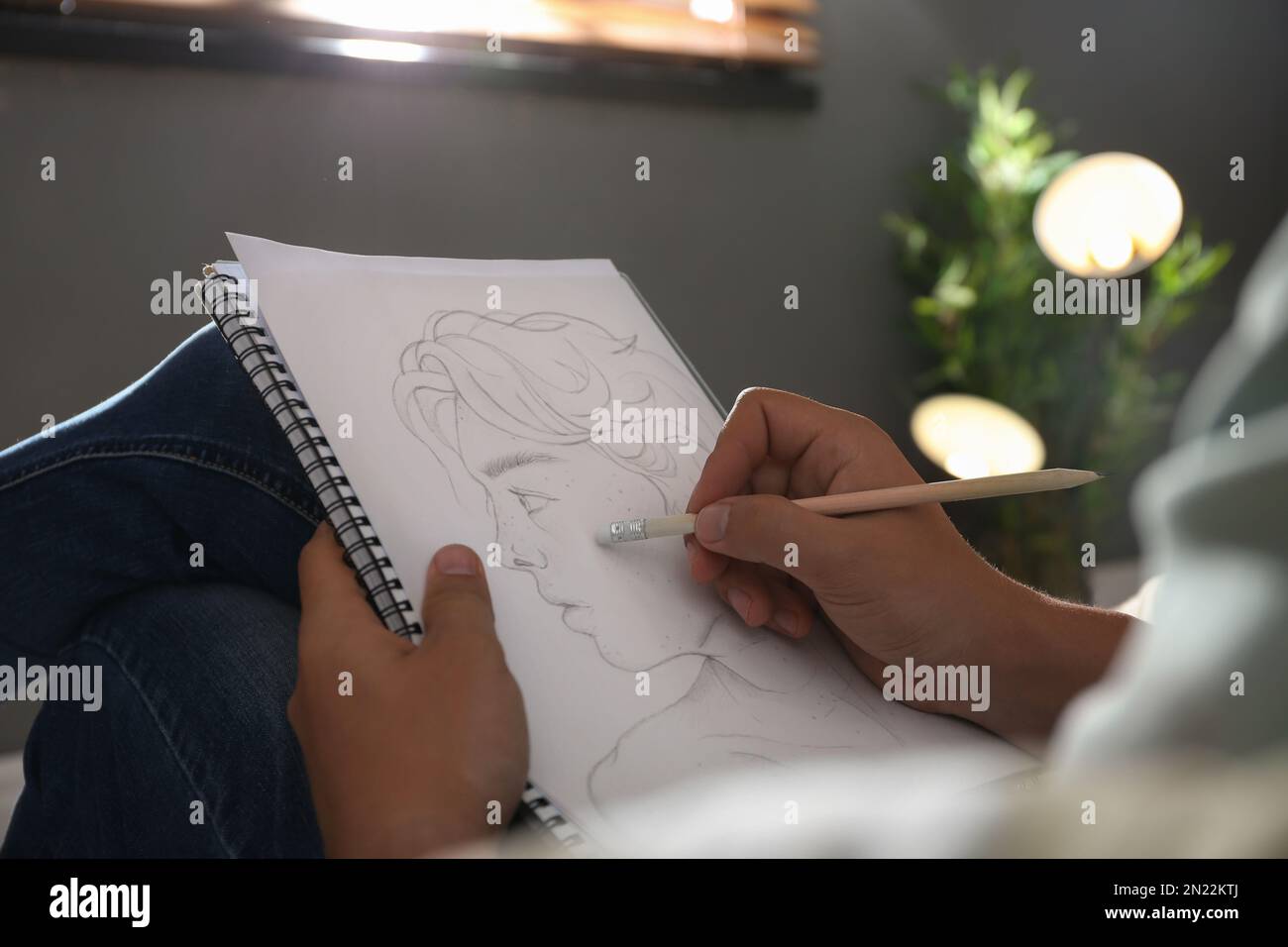 Uomo disegno ritratto con matita in blocco note interni, primo piano Foto Stock