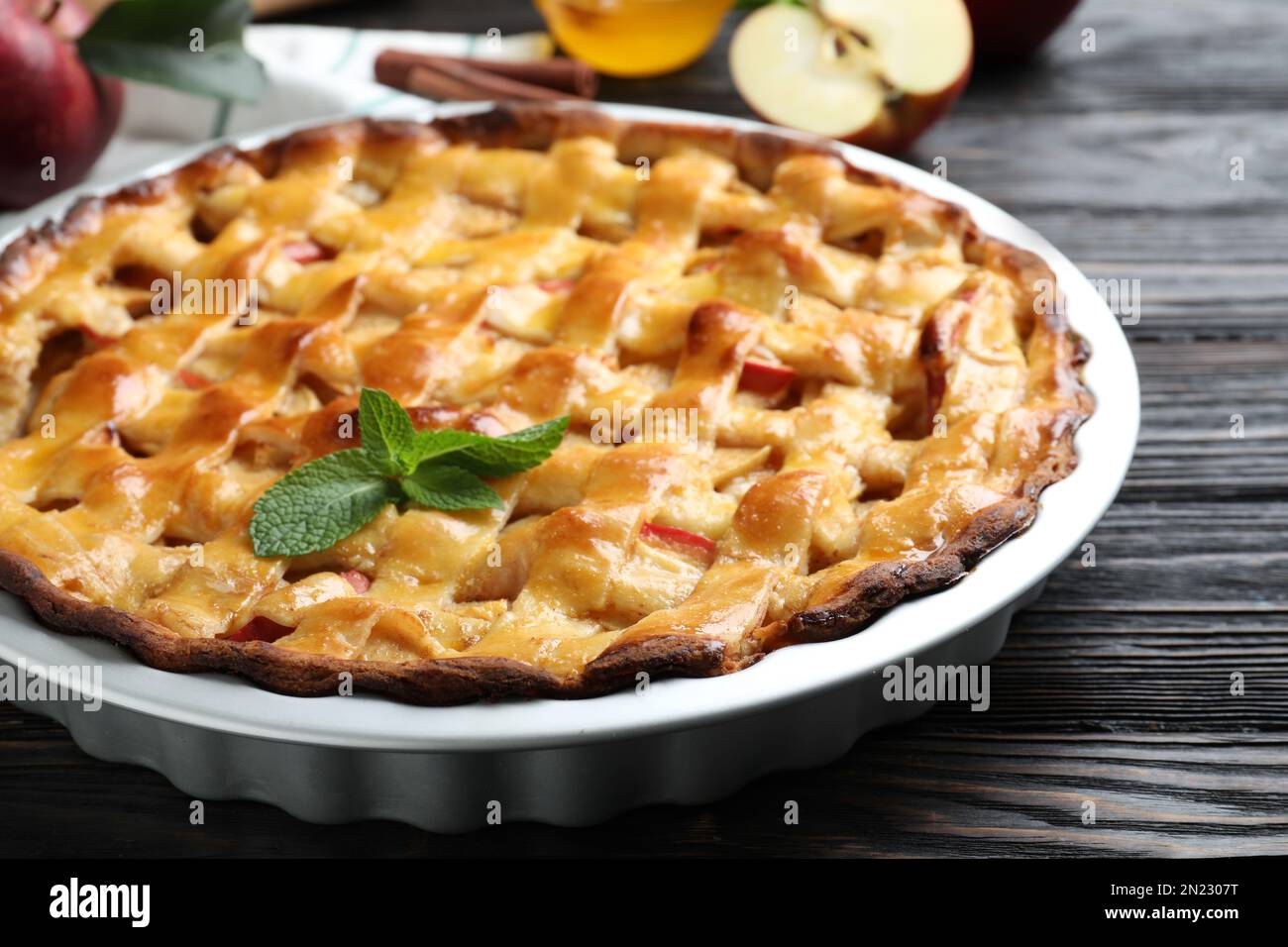 Tradizionale torta di mele con menta su tavolo di legno nero, primo piano Foto Stock