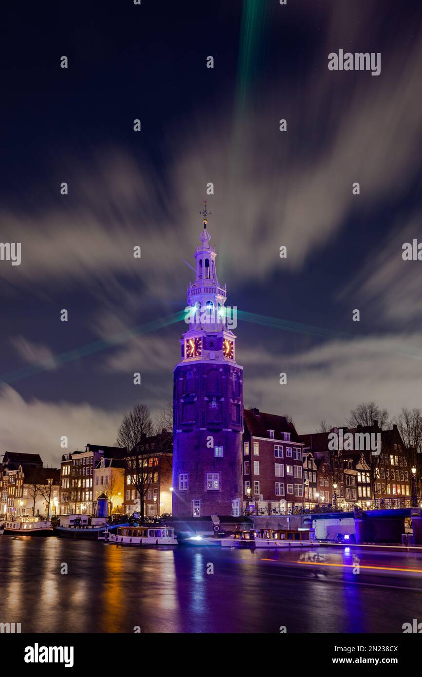 AMSTERDAM, PAESI BASSI - 18 GENNAIO 2023: Amsterdam Light Festival - raggi di luce al Montelbaanstower con raggi laser verdi. Orientamento verticale Foto Stock