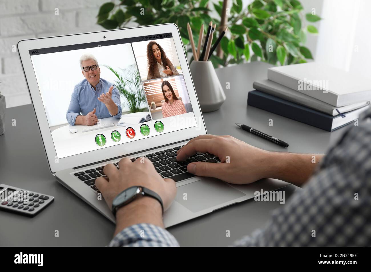 Uomo che ha video chat con i colleghi al tavolo in ufficio, primo piano. Lavoro di squadra Foto Stock