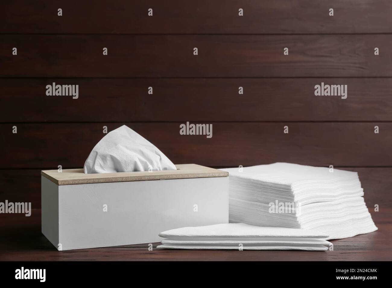 Scatola con fazzolettini e tovaglioli su tavolo di legno Foto Stock