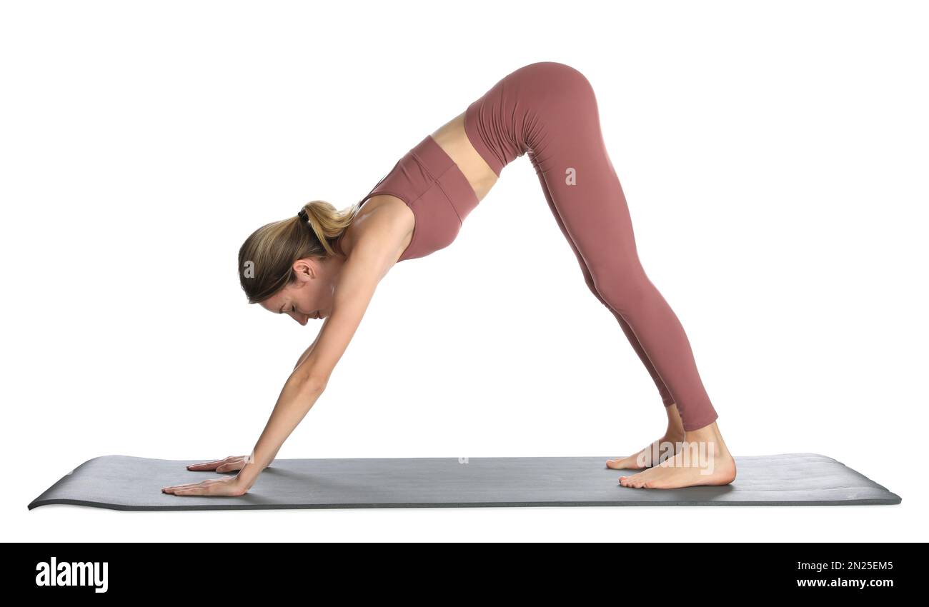 Giovane donna in abbigliamento sportivo che pratica yoga su sfondo bianco Foto Stock