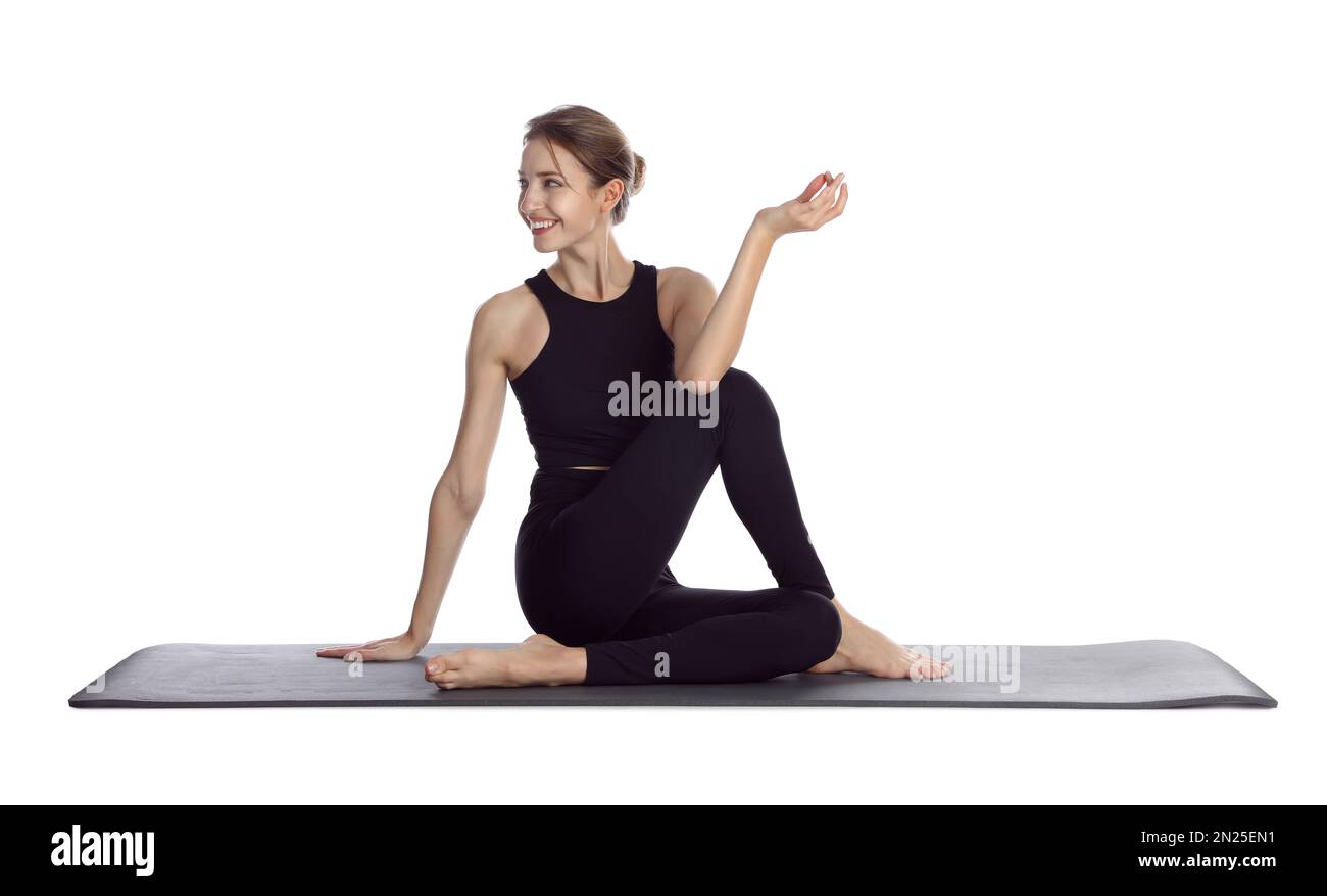 Giovane donna in abbigliamento sportivo che pratica yoga su sfondo bianco Foto Stock