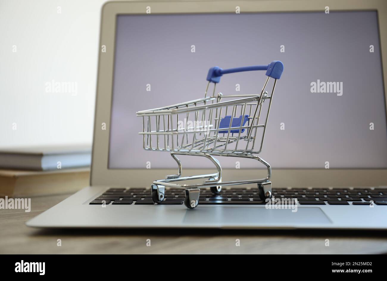 Shopping su Internet. Computer portatile con piccolo carrello sul tavolo,  primo piano Foto stock - Alamy